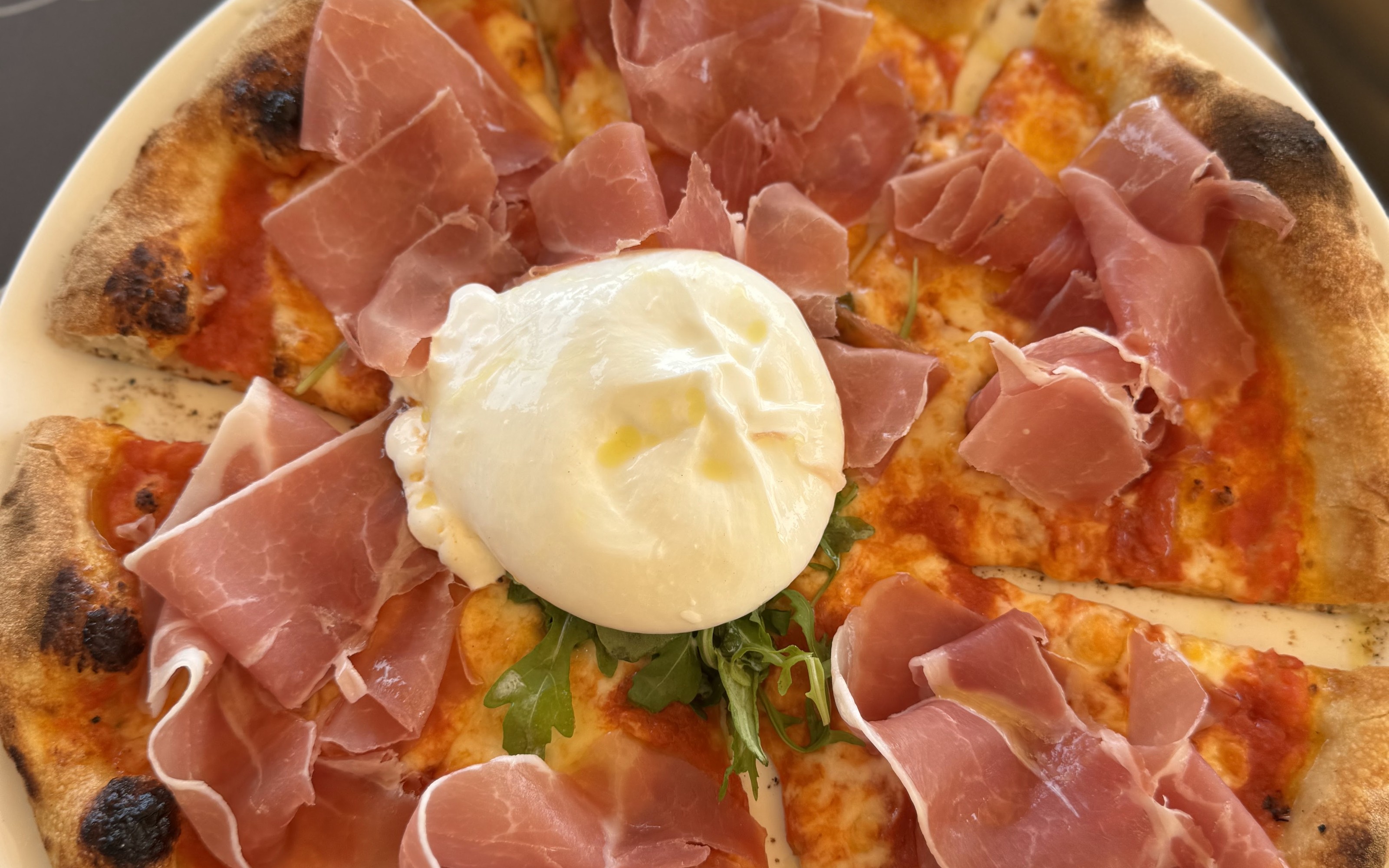 Pizza con burrata, jamón serrano y rúcula, vista desde arriba